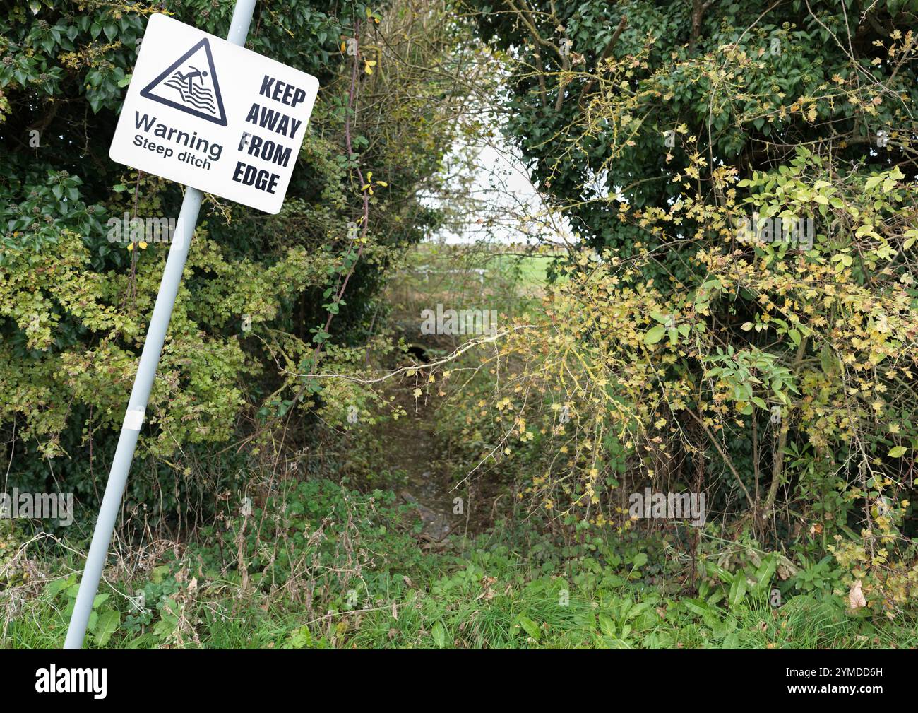 Avviso: "Avviso fosso ripido tenere lontano dal bordo" all'ippodromo di Brampton, Huntingdon, Inghilterra. Foto Stock