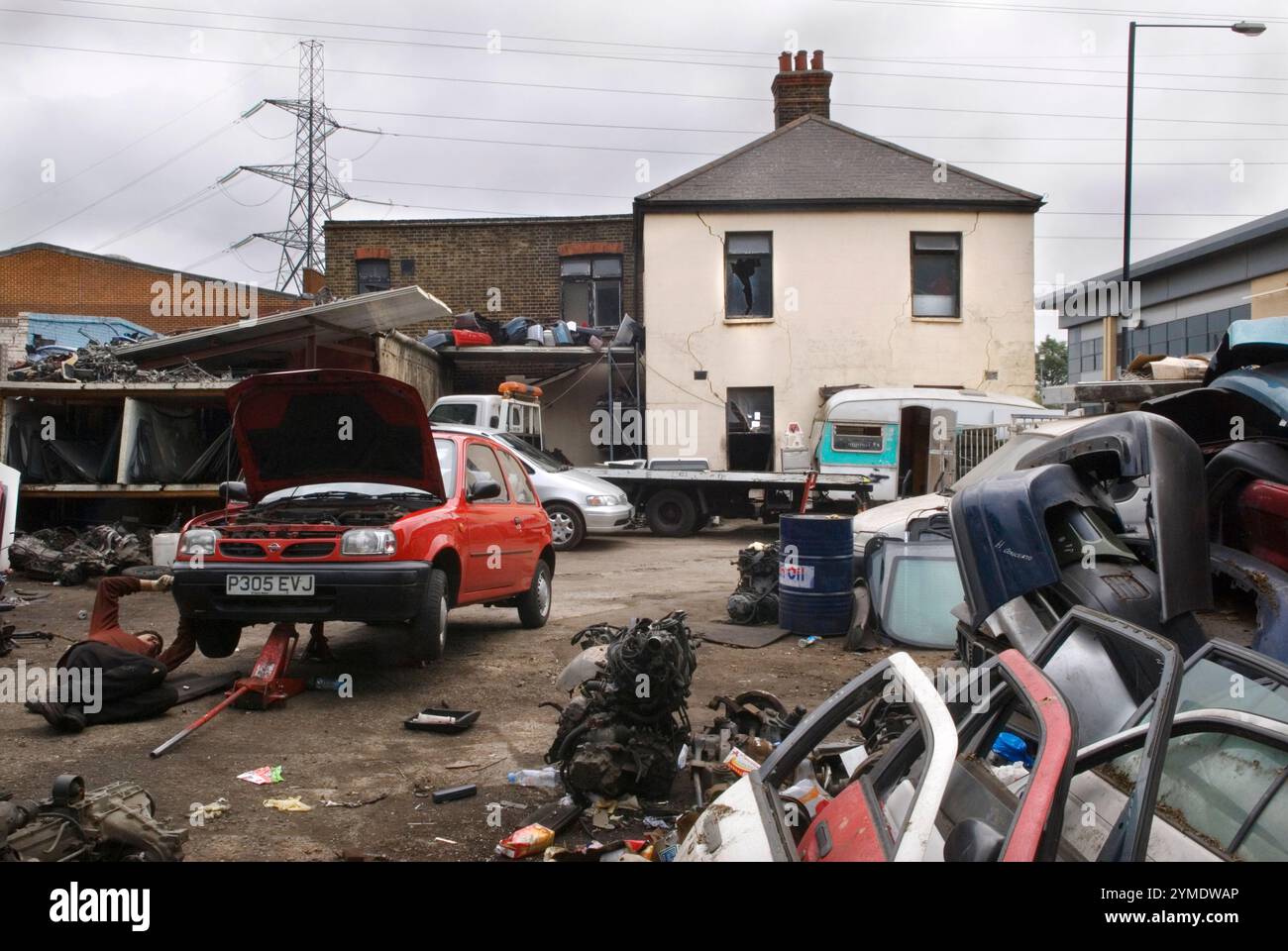 Pezzi di ricambio per auto, vecchi usati recuperati, meccanico che lavora in un garage e un deposito ricambi auto all'incrocio tra Carpenter Road e Waterden Road E9. East London, la valle della bassa Lea, sede dei Giochi Olimpici di Londra del 2012, 7 giugno 2007 2000, UK HOMER SYKES Foto Stock