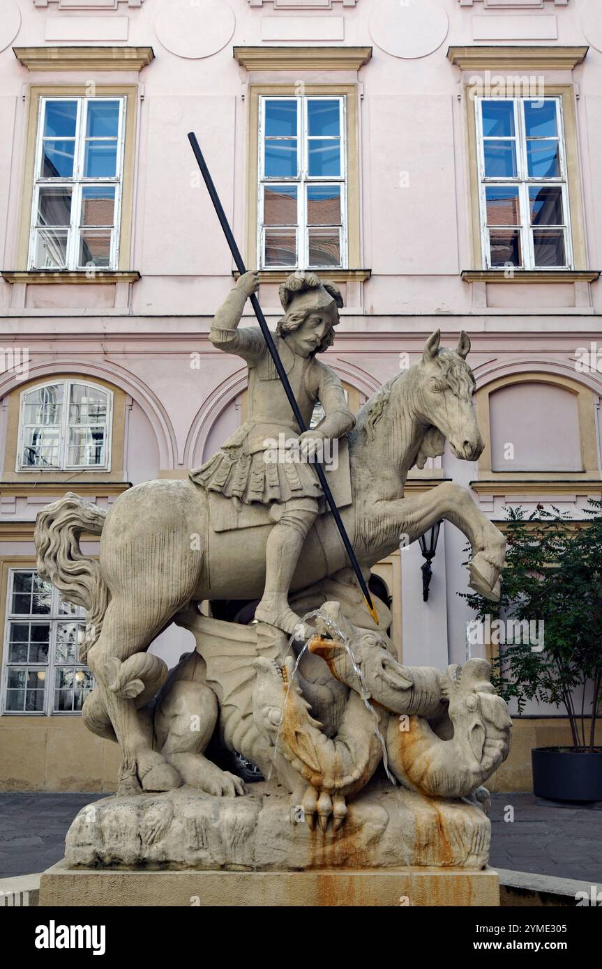 Una fontana con una scultura raffigurante San Giorgio che uccide un drago si erge in un cortile dello storico Palazzo dei Primati di Bratislava. Foto Stock