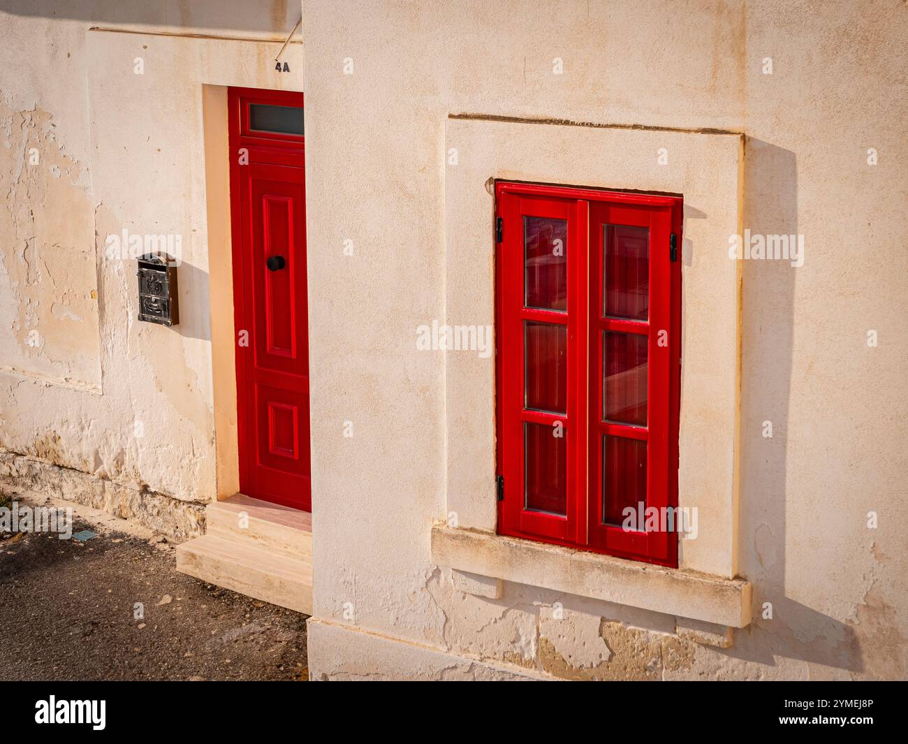 Una porta rossa e una finestra di un appartamento storico a la Valletta, Malta 2024 Foto Stock