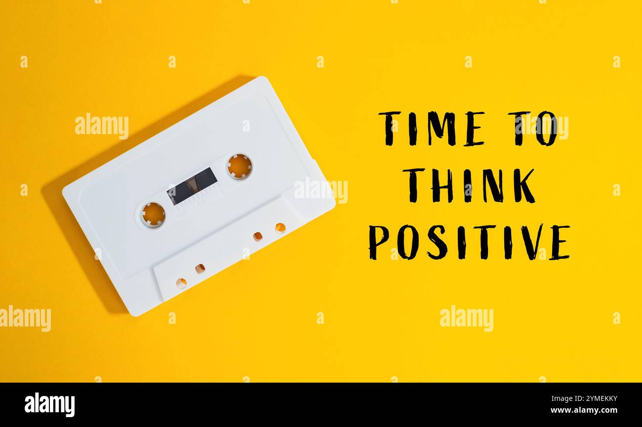 Il nastro bianco è su sfondo giallo con le parole Time to think positive scritte sotto di esso Foto Stock