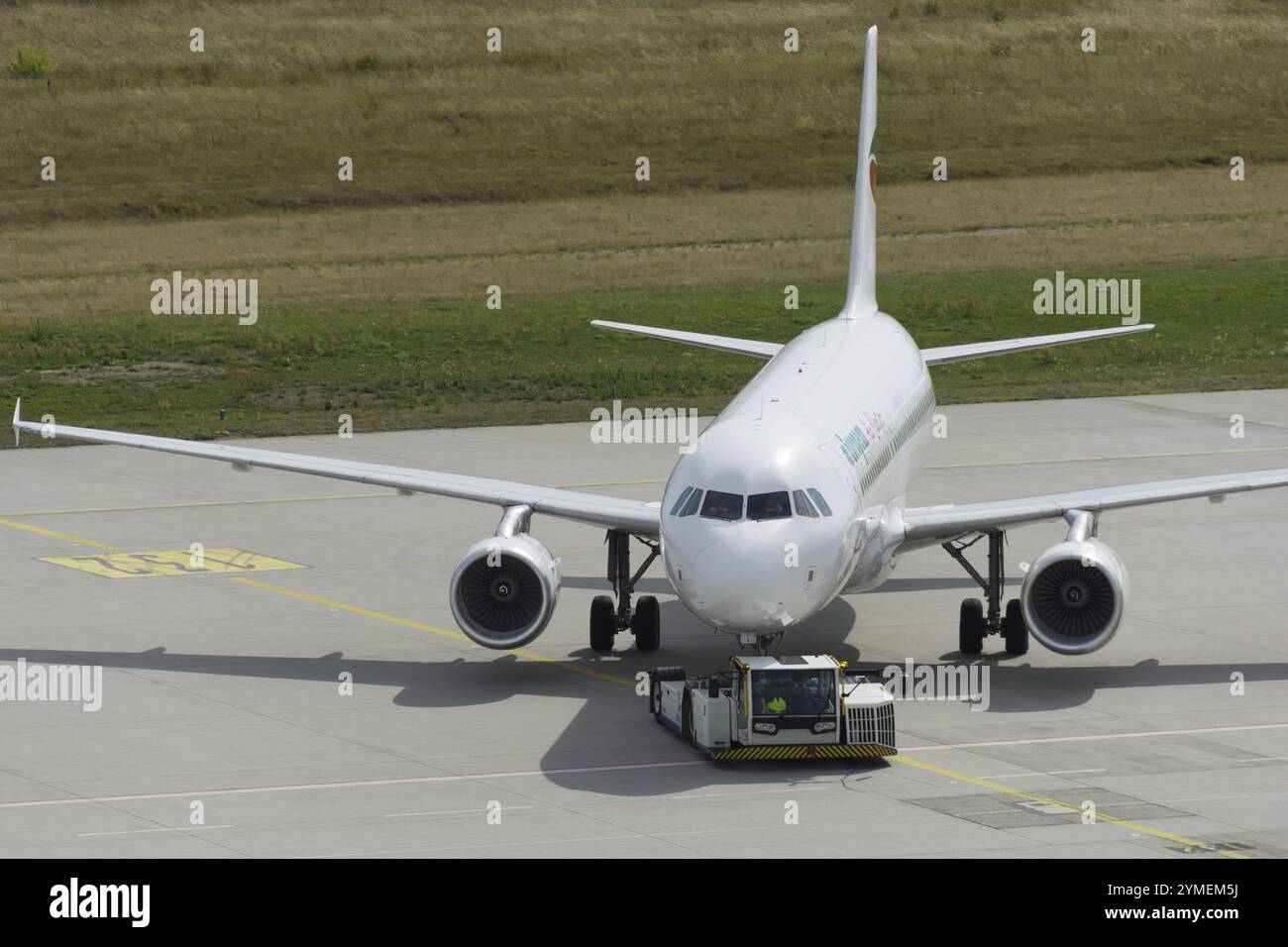 Il rimorchiatore dell'aereo spinge il getto all'indietro fuori dalla posizione di parcheggio Foto Stock