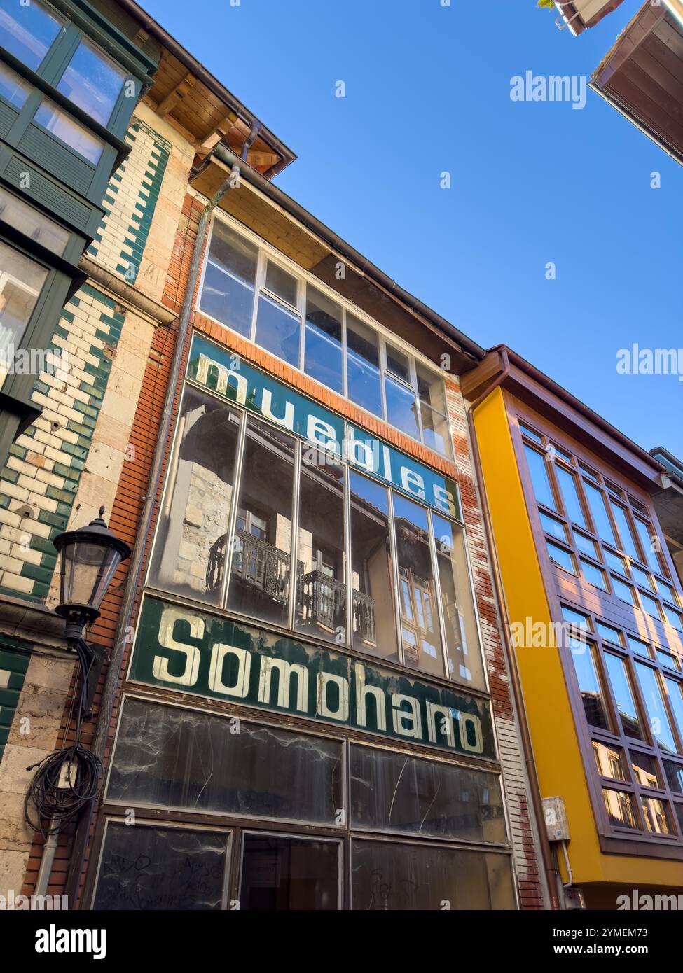 Il vecchio negozio di mobili è stato chiuso come segno del processo di gentrificazione della città vecchia di Llanes, Asturie, Spagna - Immagine stock catturata con smartphone