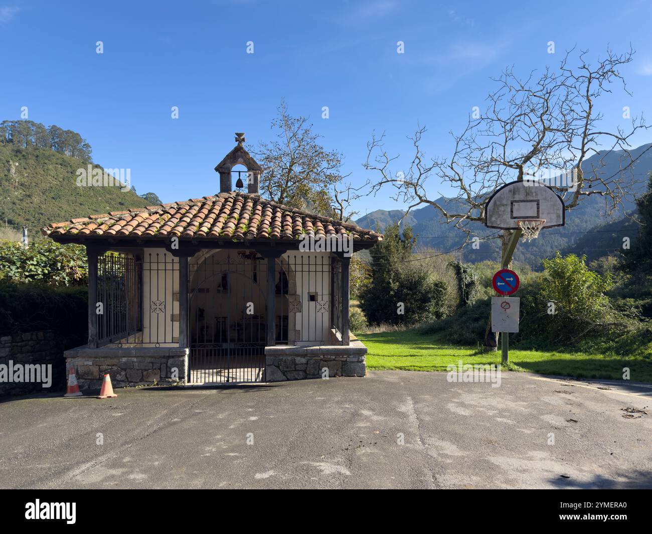 L'eremo di Santiago e un canestro da basket nel piccolo villaggio di Cuevas del Agua, Asturie, Spagna Foto Stock