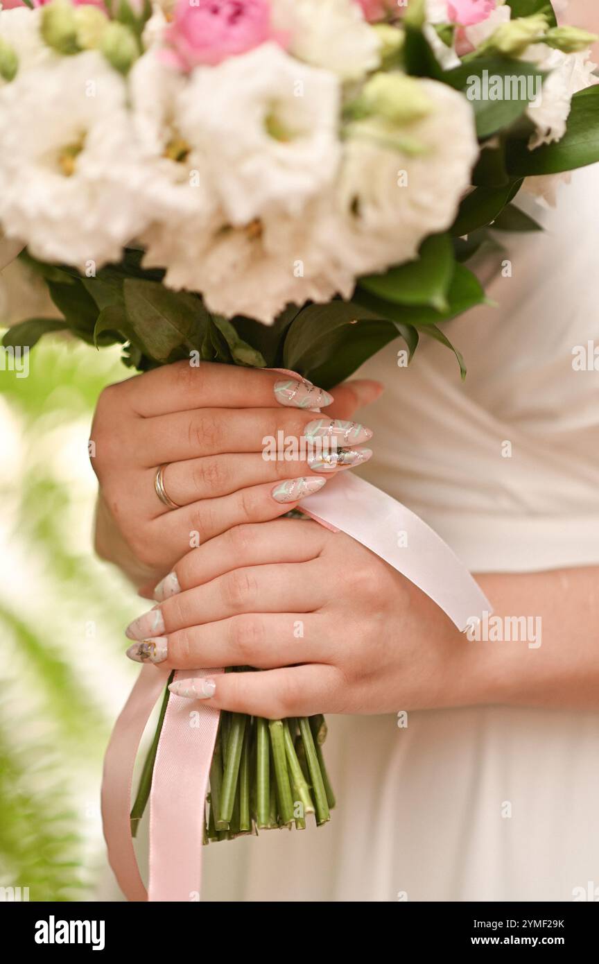 le mani delle donne tengono in mano un mazzo di fiori. primo piano Foto Stock