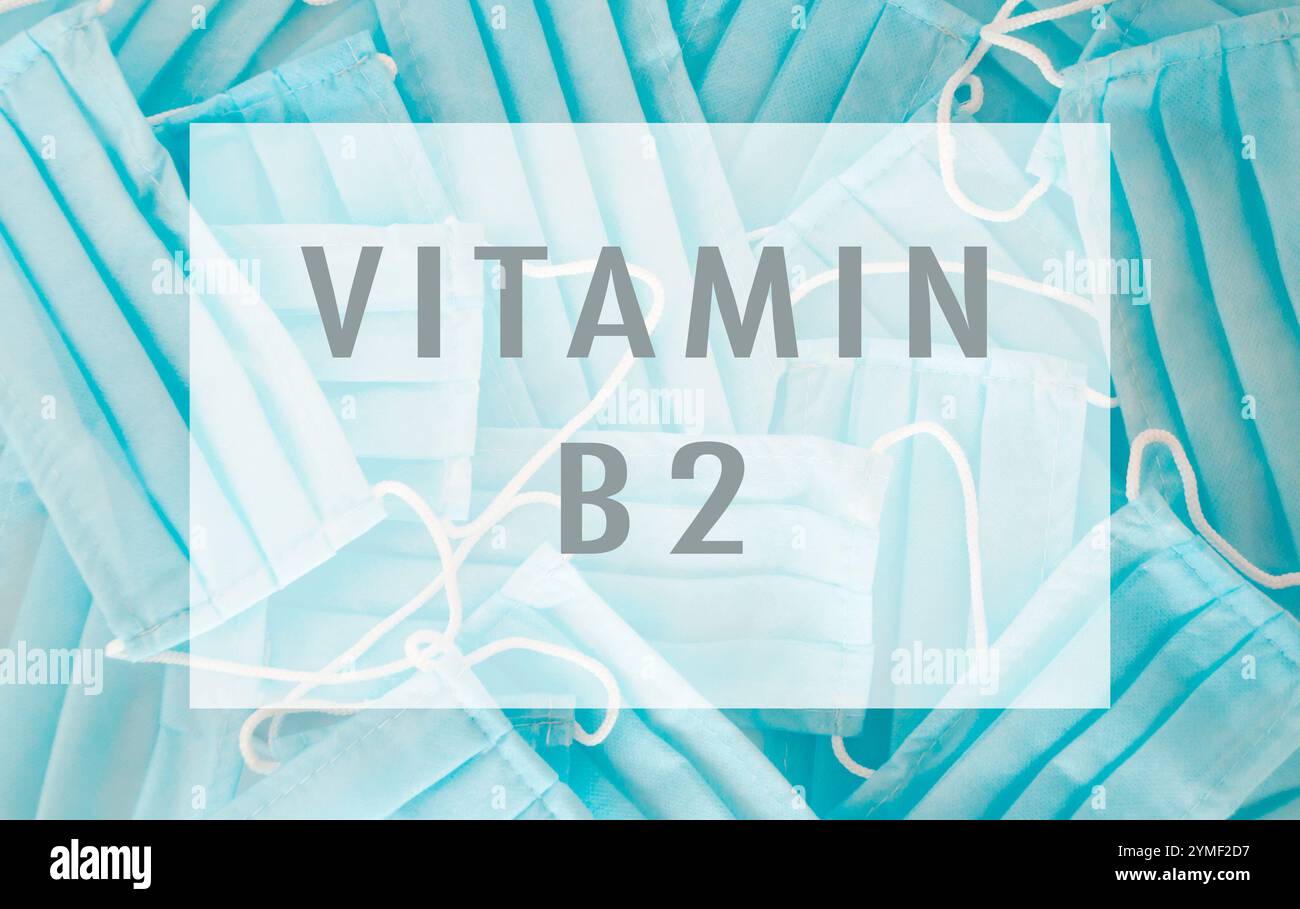 Sfondo blu con una parola bianca e blu che dice vitamina b2. Lo sfondo è pieno di maschere blu Foto Stock