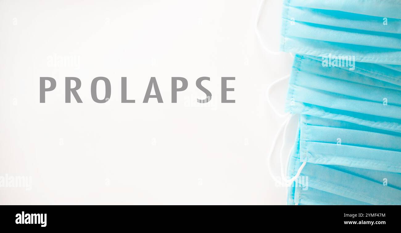 Pila di maschere chirurgiche blu con la parola prolasso scritta in bianco. Concetto di professionalità e pulizia, in quanto le maschere sono utilizzate in genere in m Foto Stock