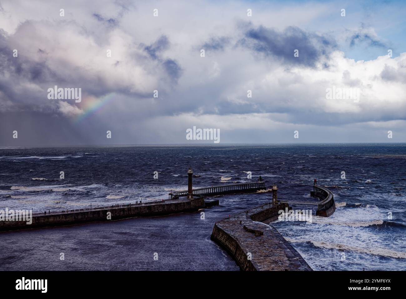 Raccogliendo nuvole di pioggia e arcobaleno sul mare a Whitby Harbour, Inghilterra. Foto Stock