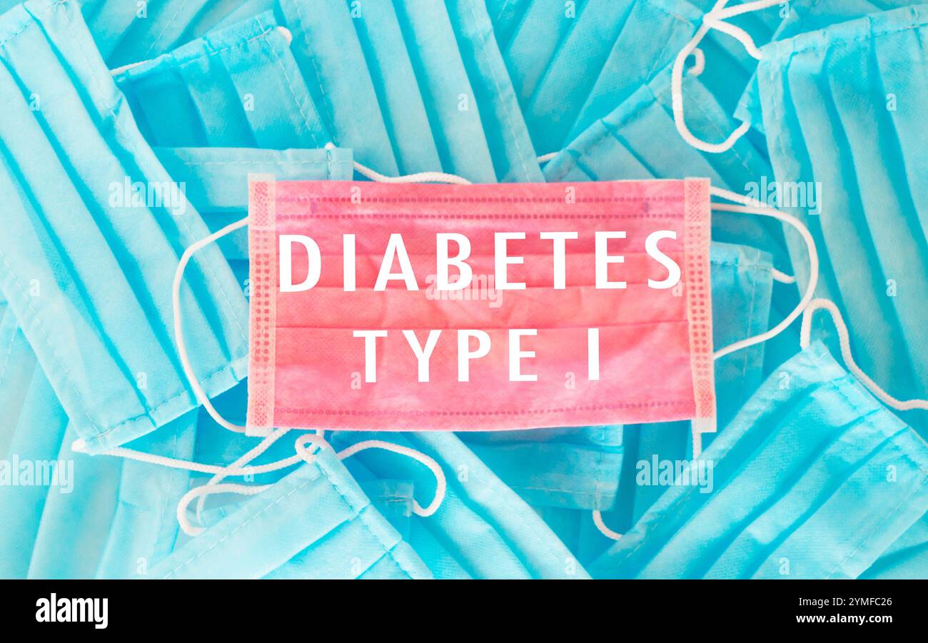 Maschera blu e rosa con sopra la parola diabete. L'immagine è di una pila di maschere con la parola diabete in cima Foto Stock
