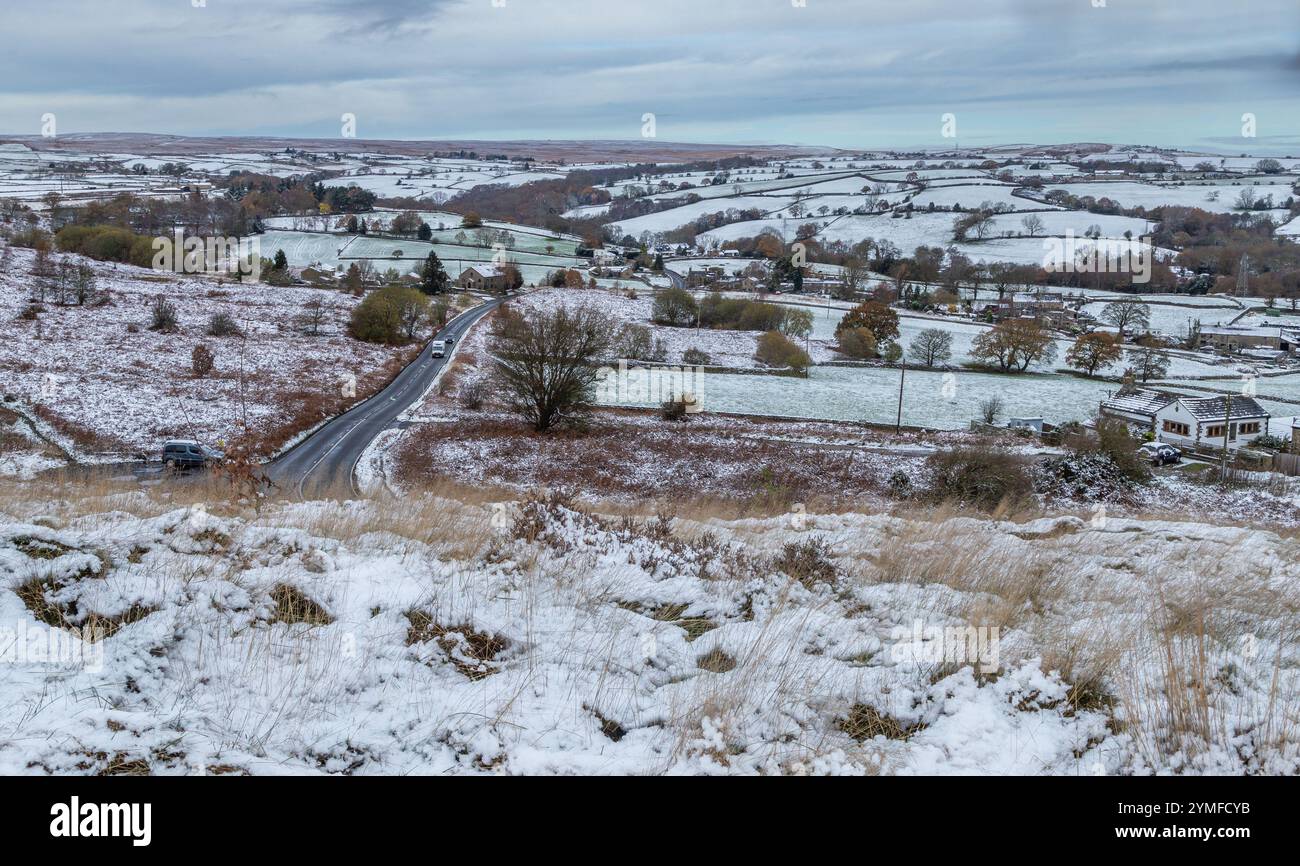 Una scena invernale nello Yorkshire. Guardando verso Rombalds Moor da Baildon Moor. Un'unica strada di campagna divide i campi. Foto Stock