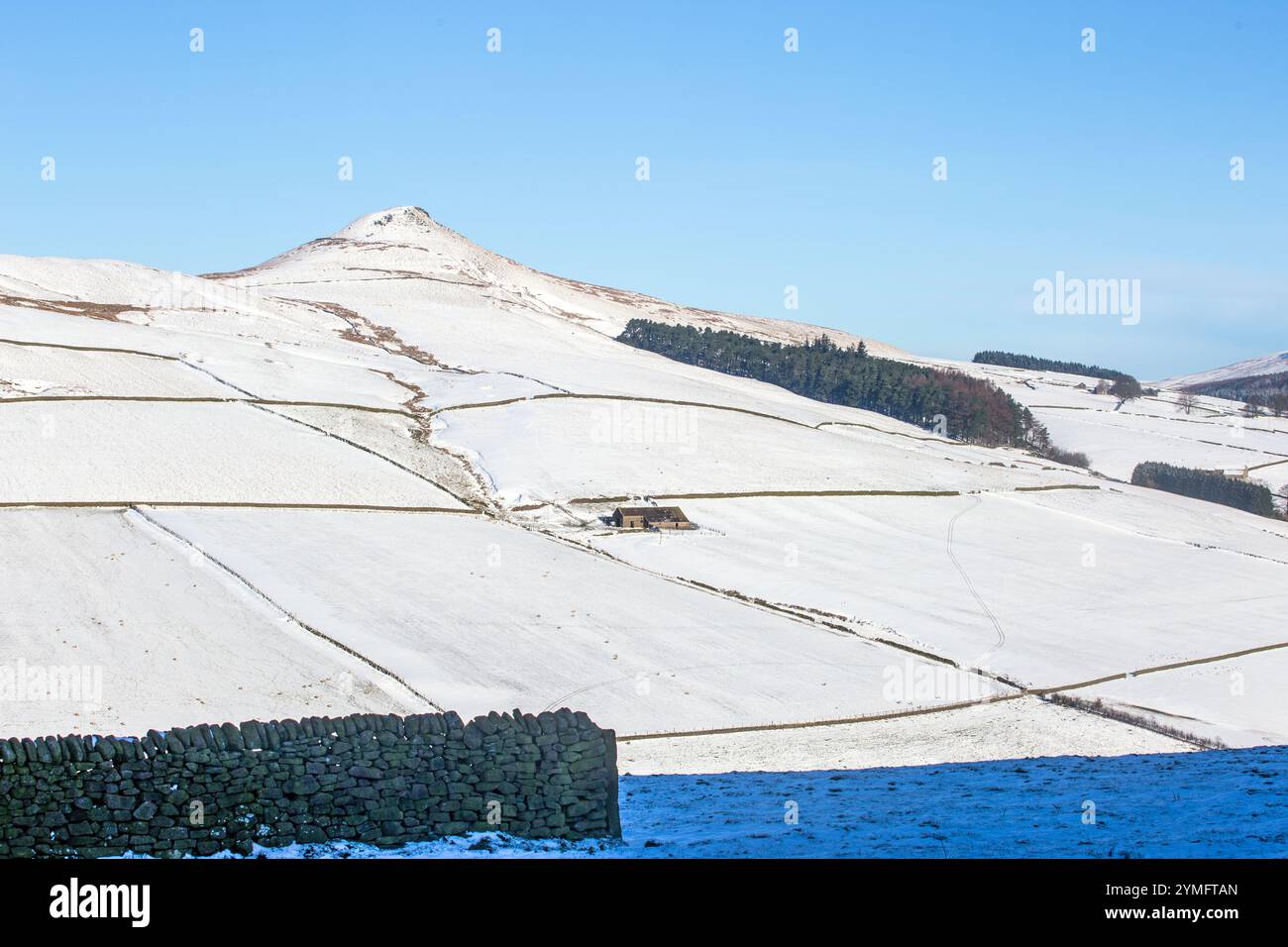 Shutlingsloe Hill in un paesaggio invernale innevato del Cheshire Peak District con una fattoria solitaria Foto Stock