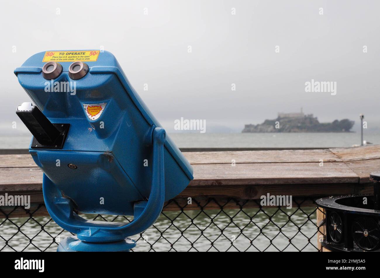 Telescopio blu che osserva la prigione di Alcatraz nella nebbiosa giornata di San Francisco Foto Stock