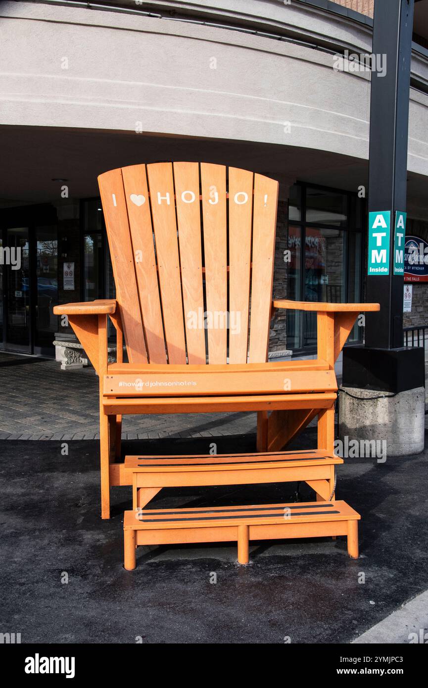 Poltrona arancione oversize Adirondack che pubblicizza l'Howard Johnson Hotel sulla Victoria Avenue a Niagara Falls, Ontario, Canada Foto Stock