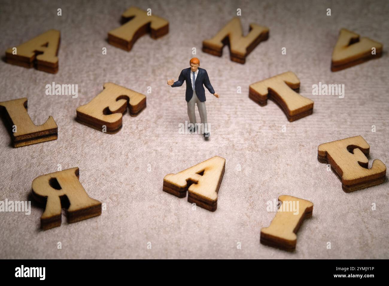Fotografia di figure giocattolo per persone in miniatura. Vista frontale uomo d'affari in mezzo all'alfabeto ALTERNATIVO. Foto immagine Foto Stock