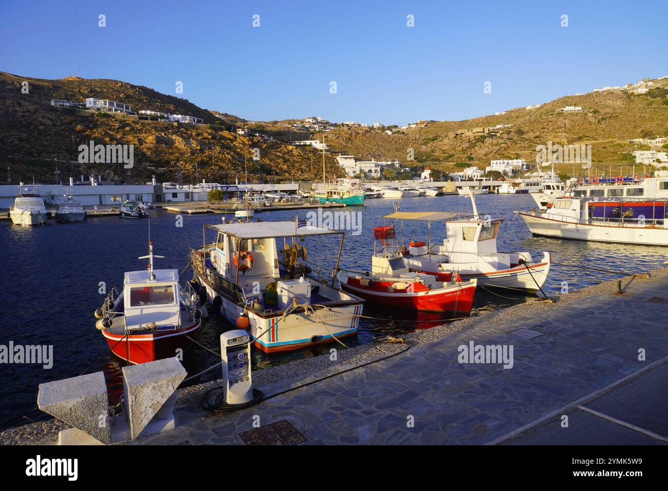 Sole serale che illumina il porto di Mykonos Foto Stock