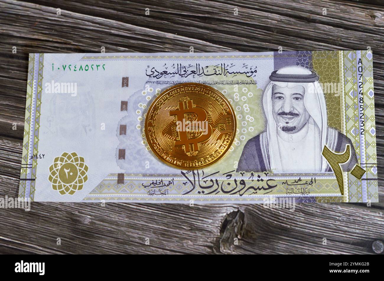 L'Arabia Saudita riyals banconota con Bitcoin moneta d'oro fisica, BTC la prima criptovaluta decentralizzata, nodi nella rete di bitcoin P2P verificano transazione Foto Stock
