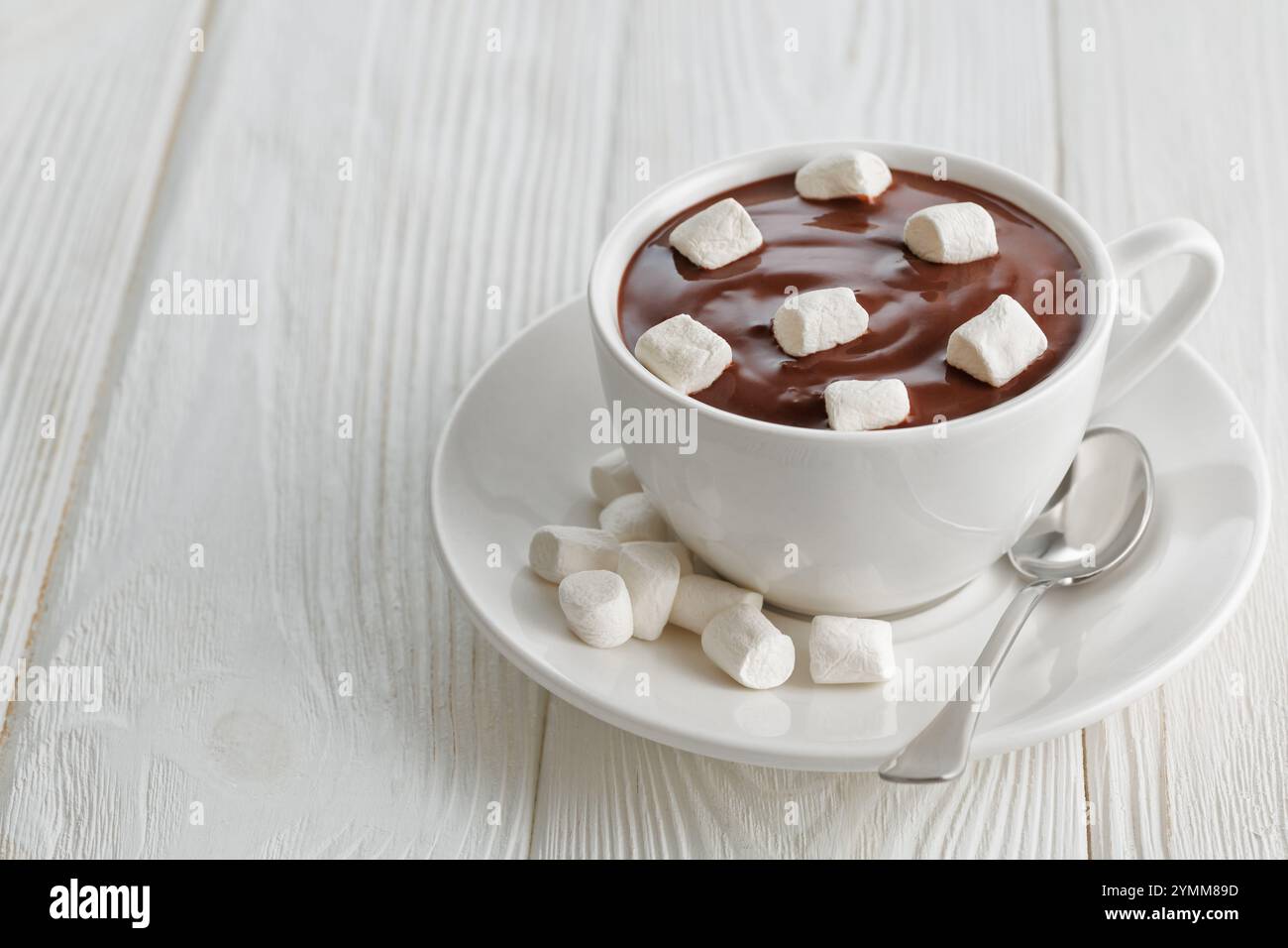 cioccolata calda con marshmallow in tazza su un tavolo di legno bianco Foto Stock
