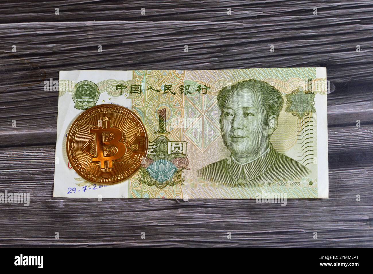Banconota Yuan con moneta d'oro fisica Bitcoin, BTC la prima criptovaluta decentralizzata, nodi nella rete bitcoin P2P verificano i transactus Foto Stock