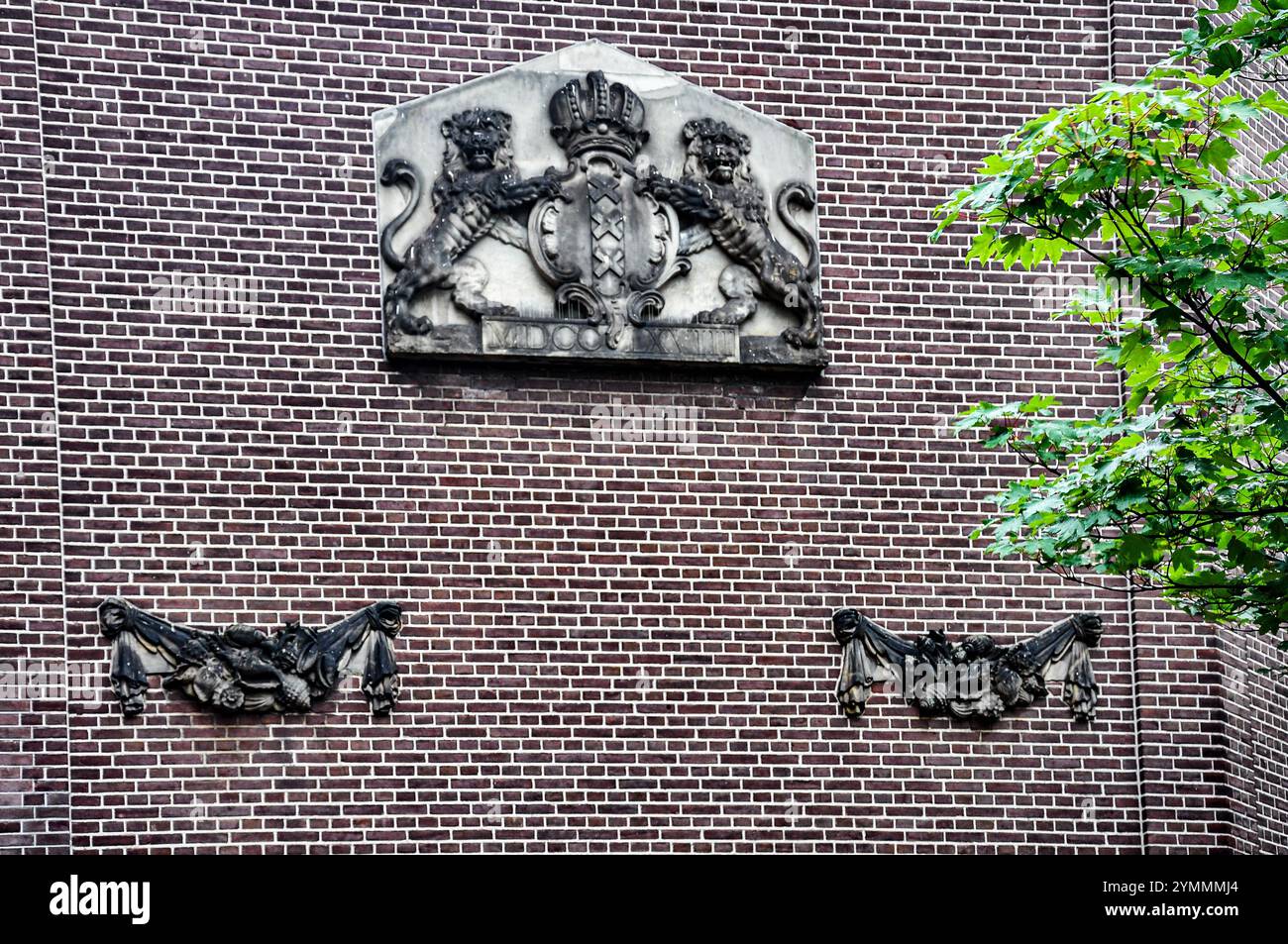 Un omaggio senza tempo: Lo stemma di Amsterdam inciso sulla parte anteriore di un edificio Foto Stock