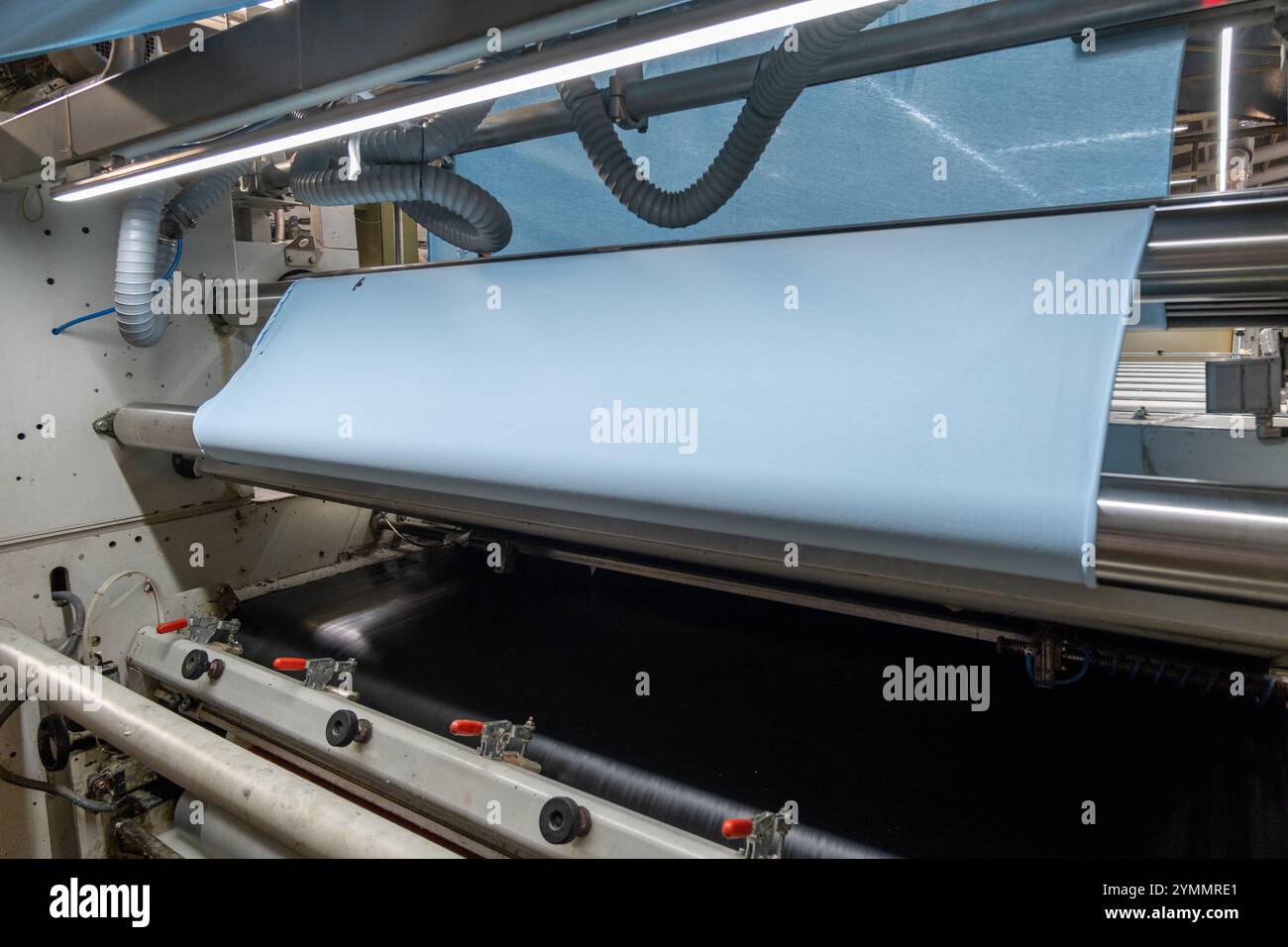 Linea di impianti industriali per macchine tessili in una fabbrica tessile. Foto Stock