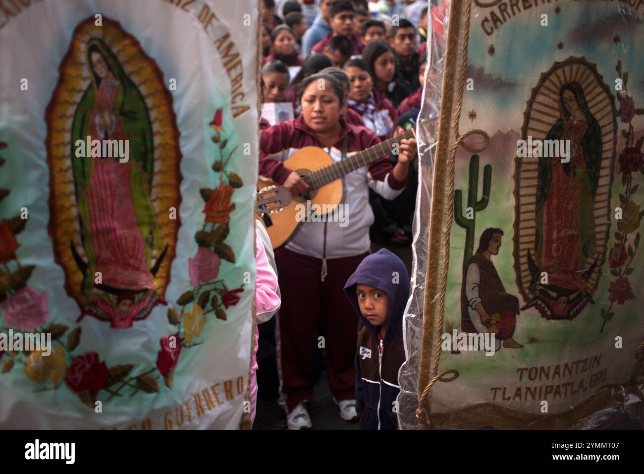 Un ragazzo sta dietro un pennant della Vergine di Guadalupe durante il pellegrinaggio annuale alla Basilica di nostra Signora di Guadalupe Foto Stock