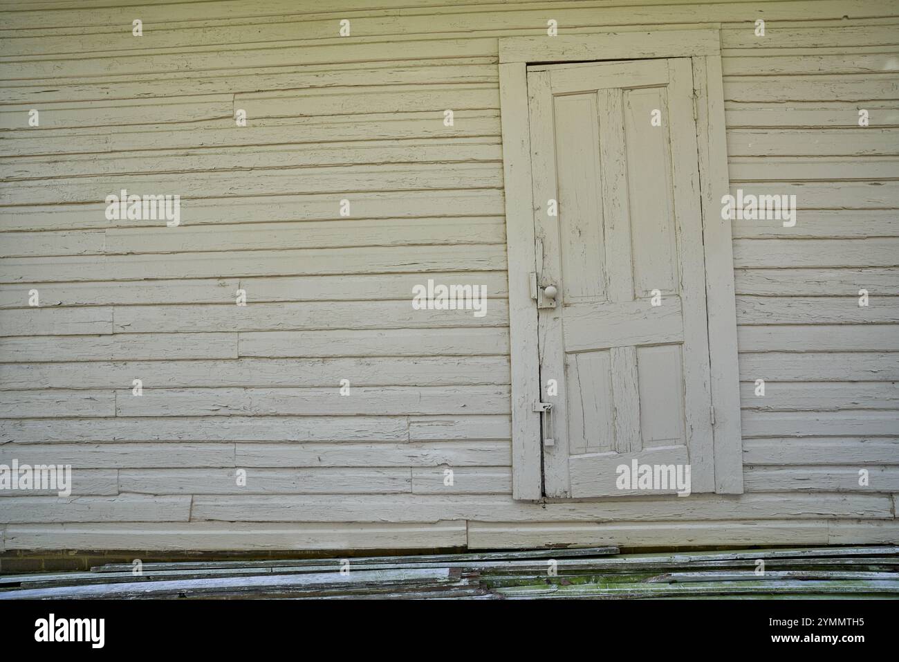 Porta storta e sbiadita sul lato della casa Foto Stock