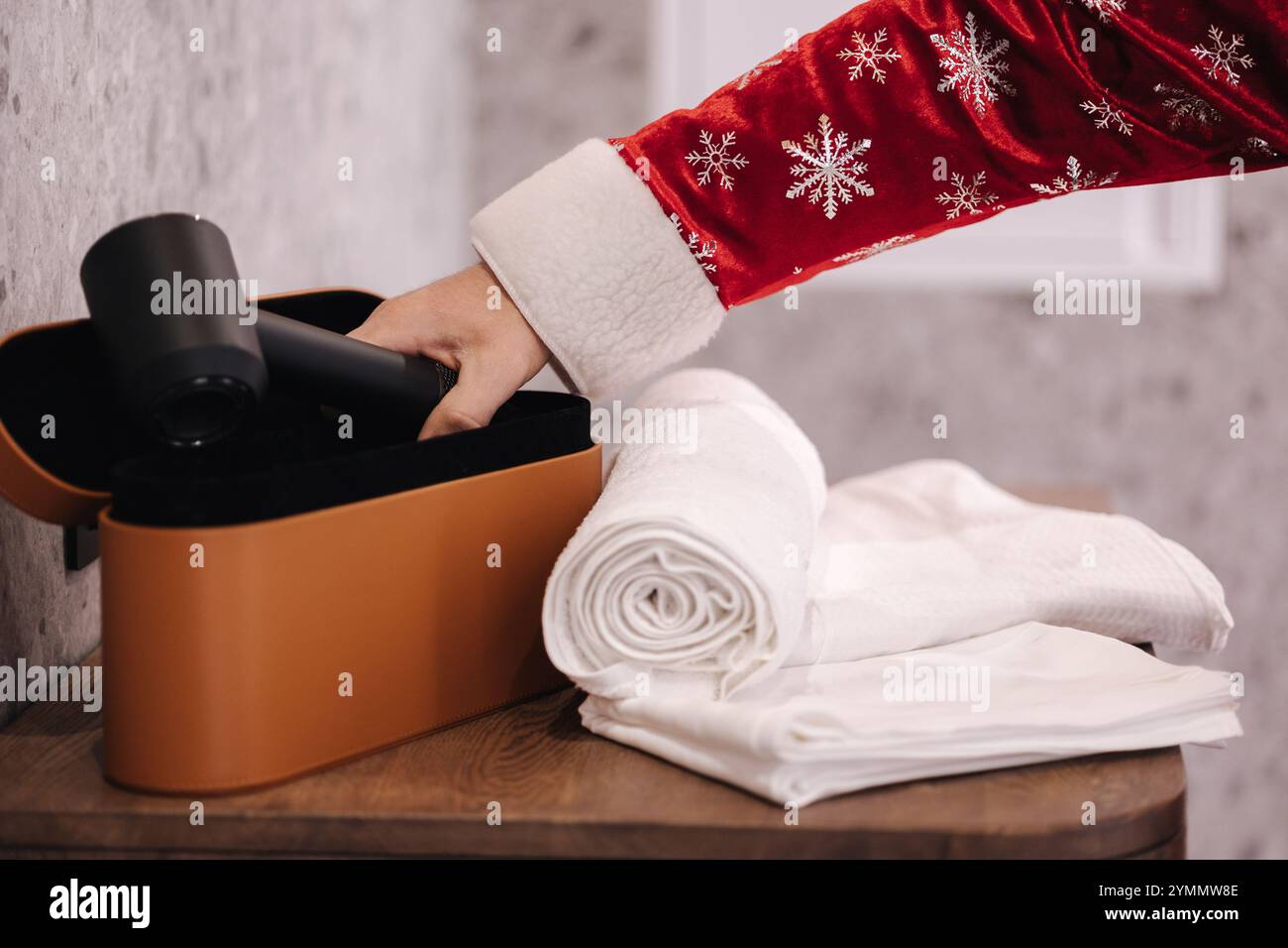 Figura a tema Babbo Natale che dispone di asciugamano e asciugacapelli, per un momento accogliente e pratico dopo la partita o in spa. Foto Stock