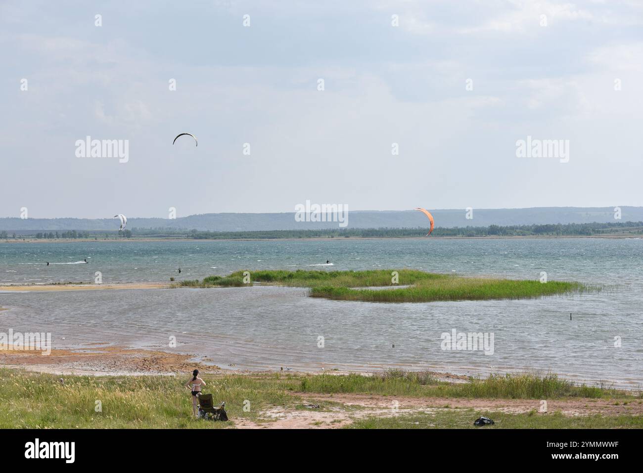 I kite surfisti scivolano attraverso le acque calme Foto Stock