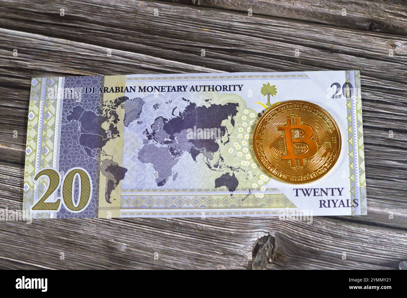 L'Arabia Saudita riyals banconota con Bitcoin moneta d'oro fisica, BTC la prima criptovaluta decentralizzata, nodi nella rete di bitcoin P2P verificano transazione Foto Stock
