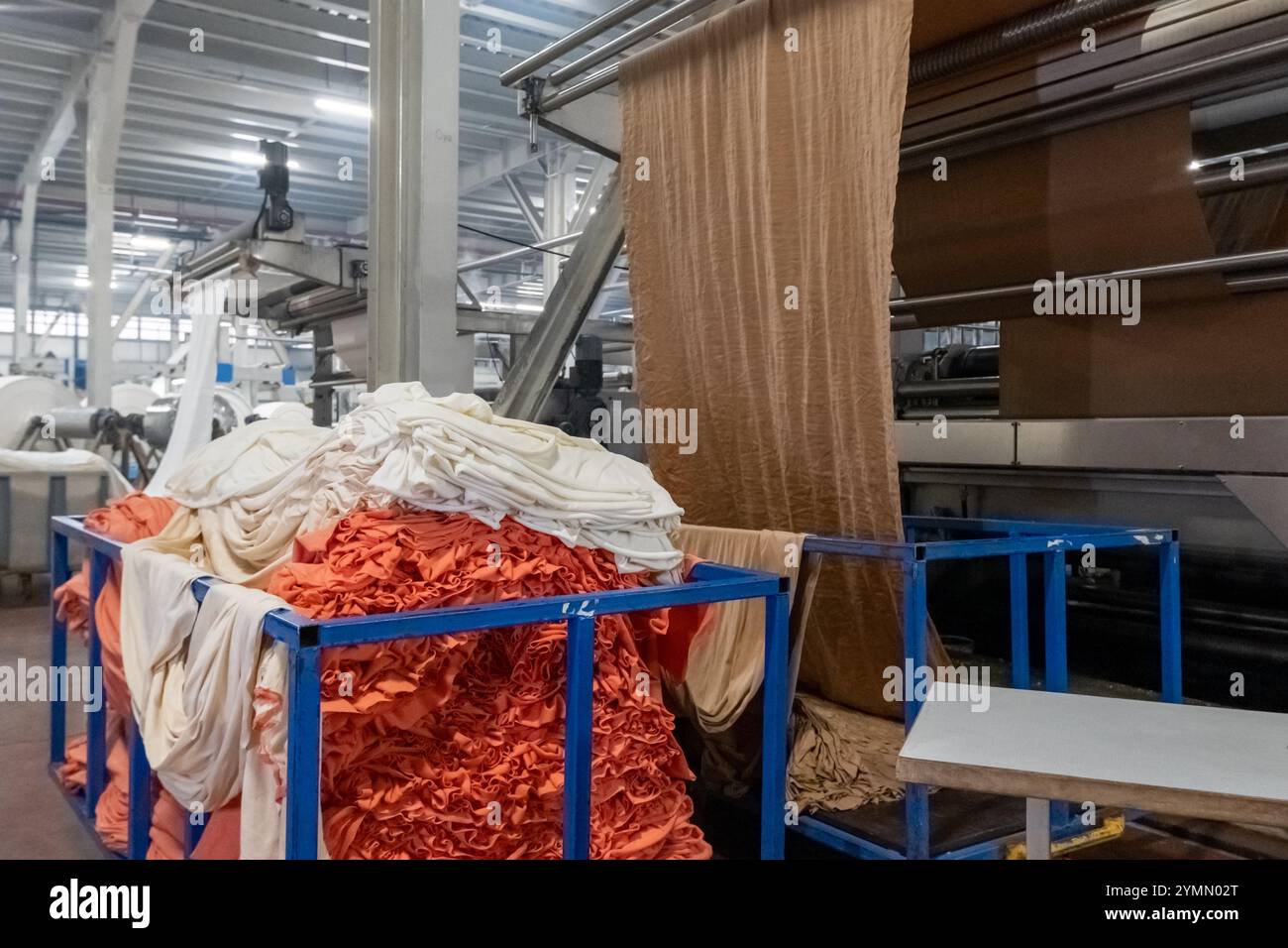 Linea di impianti industriali per macchine tessili in una fabbrica tessile. Foto Stock