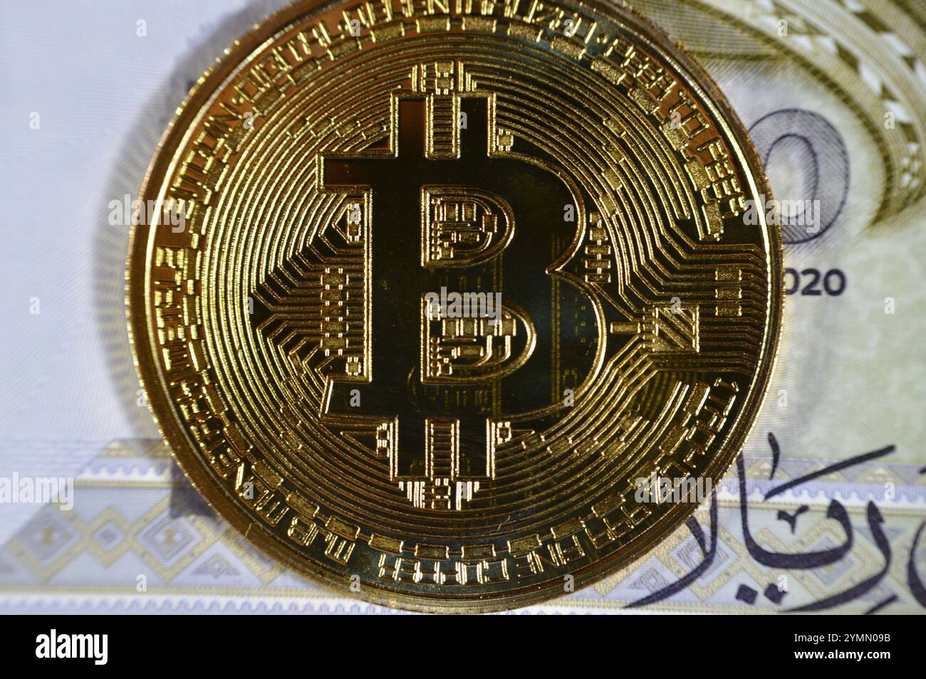 L'Arabia Saudita riyals banconota con Bitcoin moneta d'oro fisica, BTC la prima criptovaluta decentralizzata, nodi nella rete di bitcoin P2P verificano transazione Foto Stock