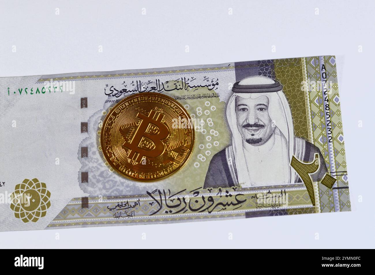 L'Arabia Saudita riyals banconota con Bitcoin moneta d'oro fisica, BTC la prima criptovaluta decentralizzata, nodi nella rete di bitcoin P2P verificano transazione Foto Stock