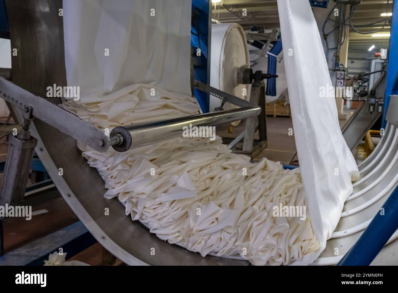 Linea di impianti industriali per macchine tessili in una fabbrica tessile. Foto Stock