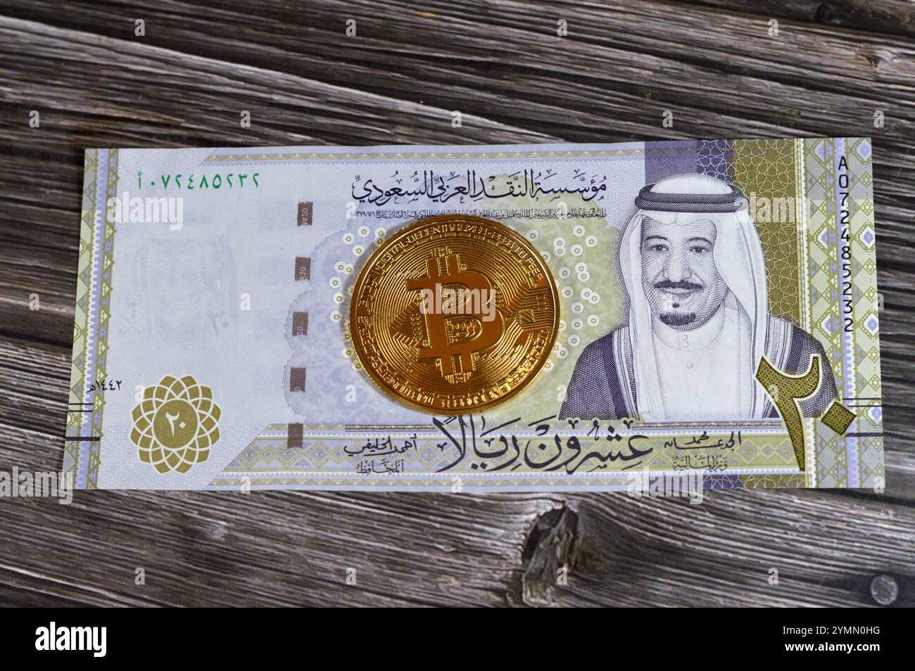 L'Arabia Saudita riyals banconota con Bitcoin moneta d'oro fisica, BTC la prima criptovaluta decentralizzata, nodi nella rete di bitcoin P2P verificano transazione Foto Stock