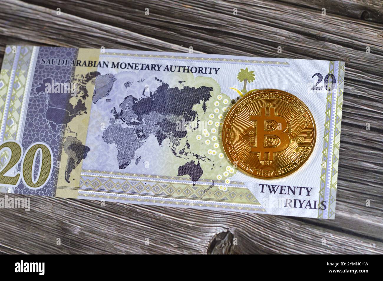 L'Arabia Saudita riyals banconota con Bitcoin moneta d'oro fisica, BTC la prima criptovaluta decentralizzata, nodi nella rete di bitcoin P2P verificano transazione Foto Stock