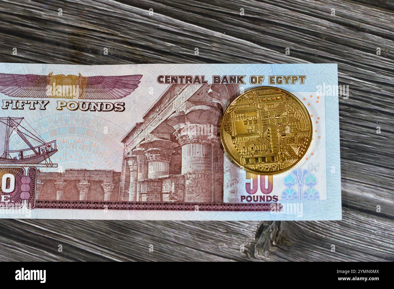 Banconota in sterline egiziane con moneta d'oro fisica Bitcoin, BTC la prima criptovaluta decentralizzata, nodi in rete bitcoin P2P verificano la transa Foto Stock