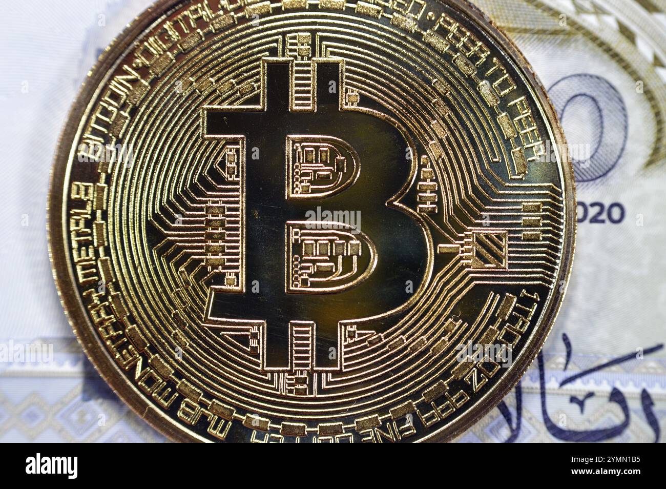 L'Arabia Saudita riyals banconota con Bitcoin moneta d'oro fisica, BTC la prima criptovaluta decentralizzata, nodi nella rete di bitcoin P2P verificano transazione Foto Stock