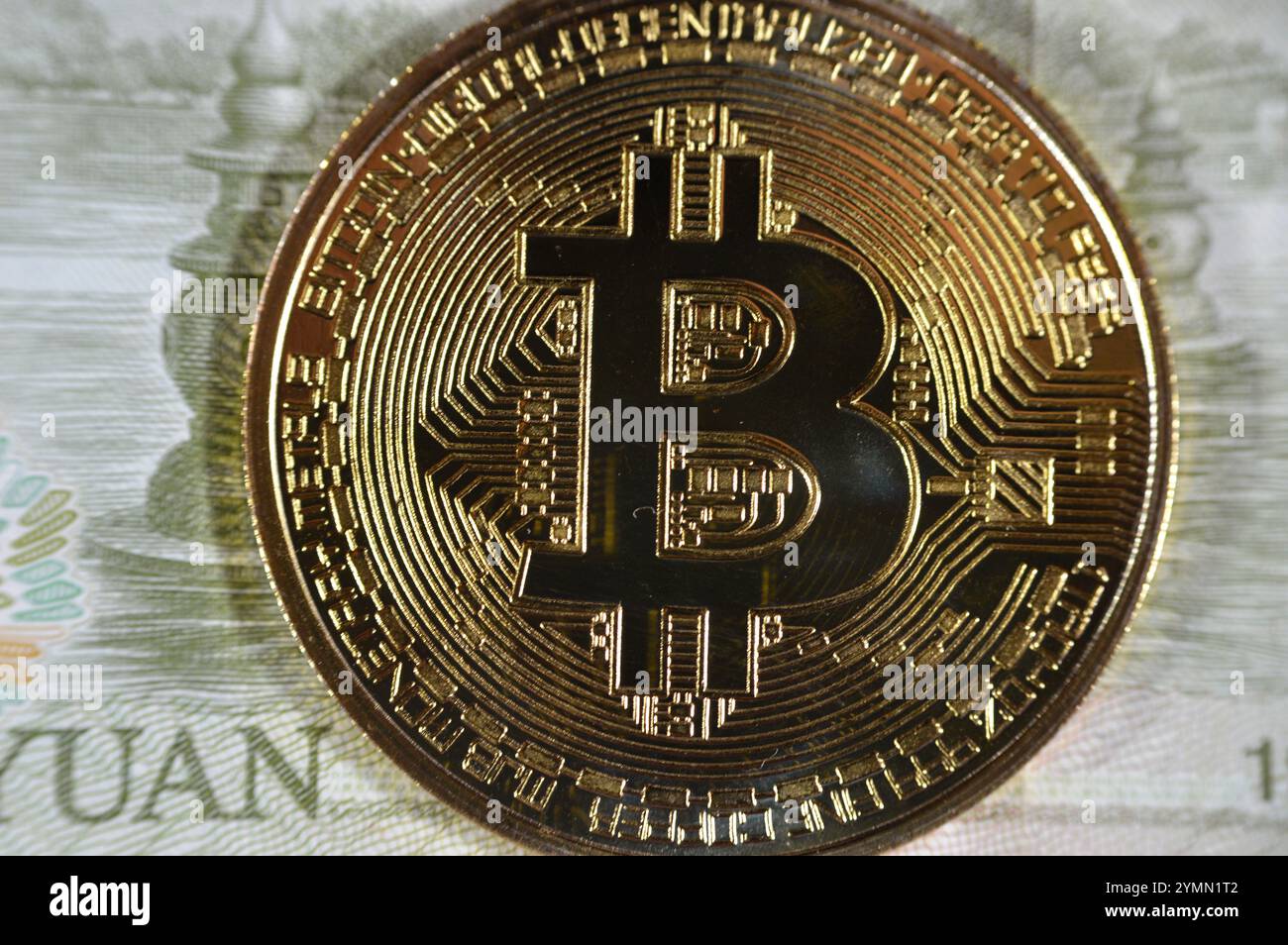 Banconota Yuan con moneta d'oro fisica Bitcoin, BTC la prima criptovaluta decentralizzata, nodi nella rete bitcoin P2P verificano i transactus Foto Stock