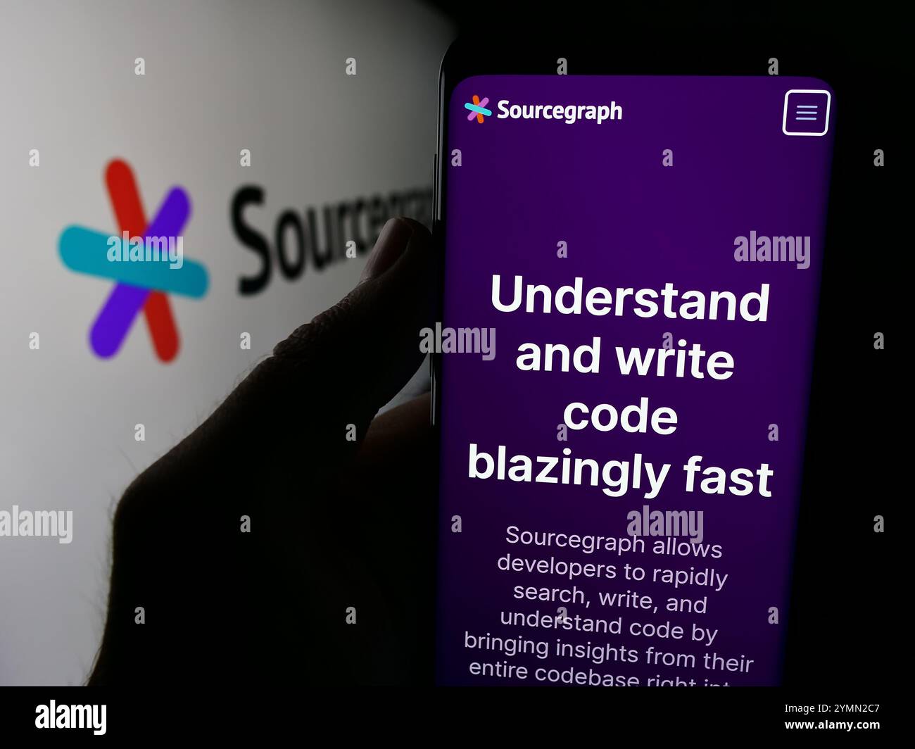 In questa immagine, una persona ha un cellulare con il sito web della società di intelligence statunitense Sourcegraph Inc. Davanti al logo. Foto Stock