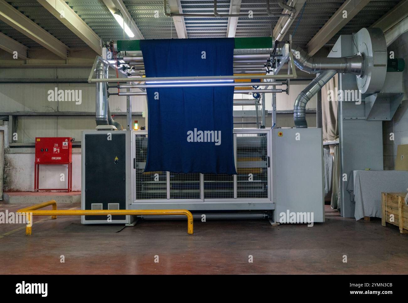 Linea di impianti industriali per macchine tessili in una fabbrica tessile. Foto Stock