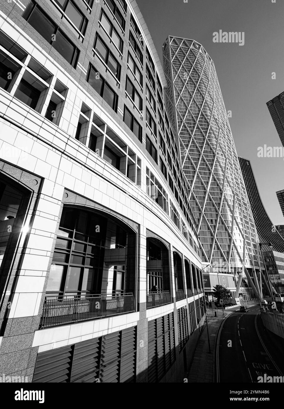 Una figura solitaria in una vista di edifici in Bank Street di fronte al Tamigi a Canary Wharf, Londra Foto Stock