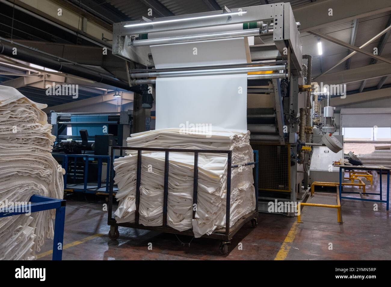 Linea di impianti industriali per macchine tessili in una fabbrica tessile. Foto Stock