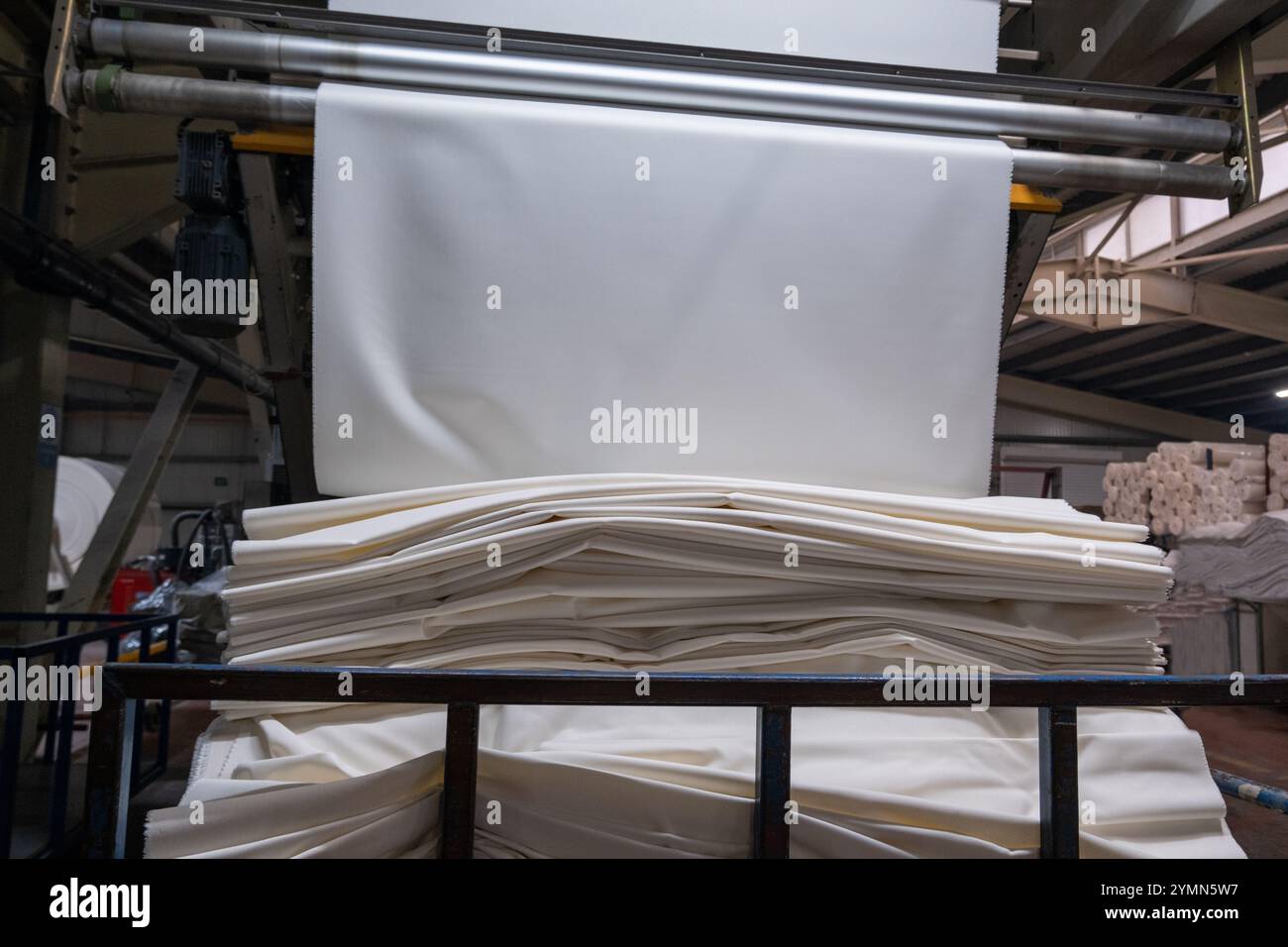 Linea di impianti industriali per macchine tessili in una fabbrica tessile. Foto Stock
