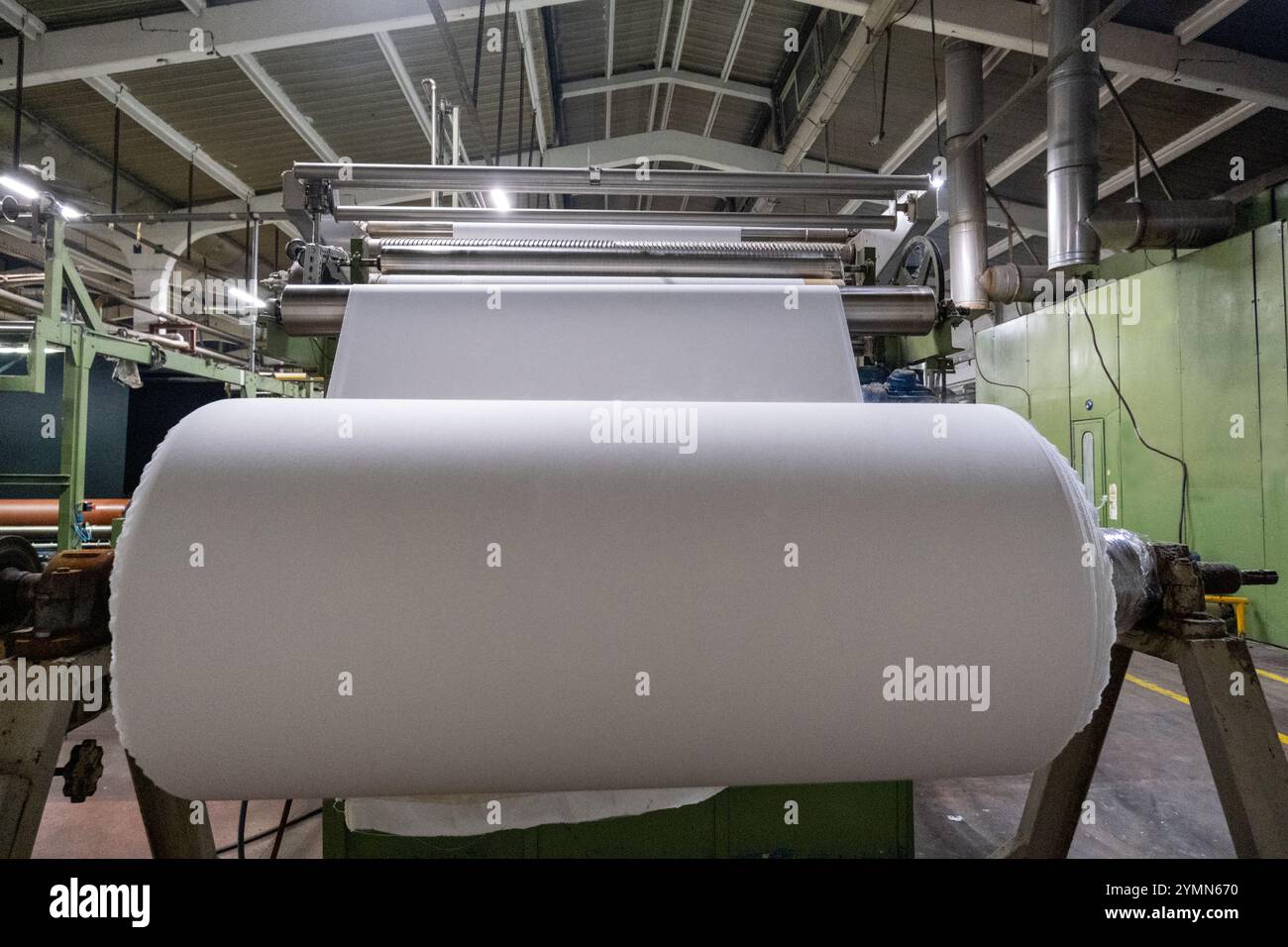 Linea di impianti industriali per macchine tessili in una fabbrica tessile. Foto Stock