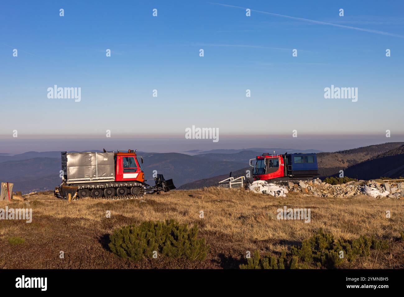 Due macchine rosse per la rimozione della neve da montagna tracciate su una pendenza. Foto Stock