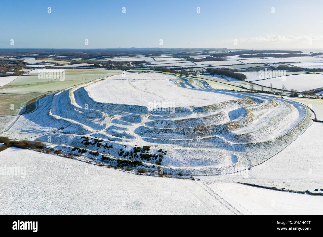 Maiden Castle, Dorchester, Dorset, Regno Unito. 22 novembre 2024. Meteo nel Regno Unito. La neve ricopre ancora il terreno presso lo storico forte collinare del Castello di Maiden a Dorchester nel Dorset in una fredda mattina di sole dopo la pesante nevicata di ieri. Crediti fotografici: Graham Hunt/Alamy Live News Foto Stock