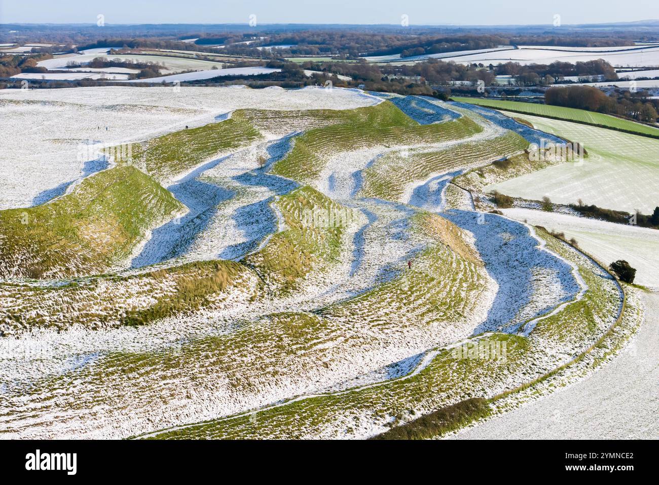 Maiden Castle, Dorchester, Dorset, Regno Unito. 22 novembre 2024. Meteo nel Regno Unito. La neve ricopre ancora il terreno presso lo storico forte collinare del Castello di Maiden a Dorchester nel Dorset in una fredda mattina di sole dopo la pesante nevicata di ieri. Crediti fotografici: Graham Hunt/Alamy Live News Foto Stock