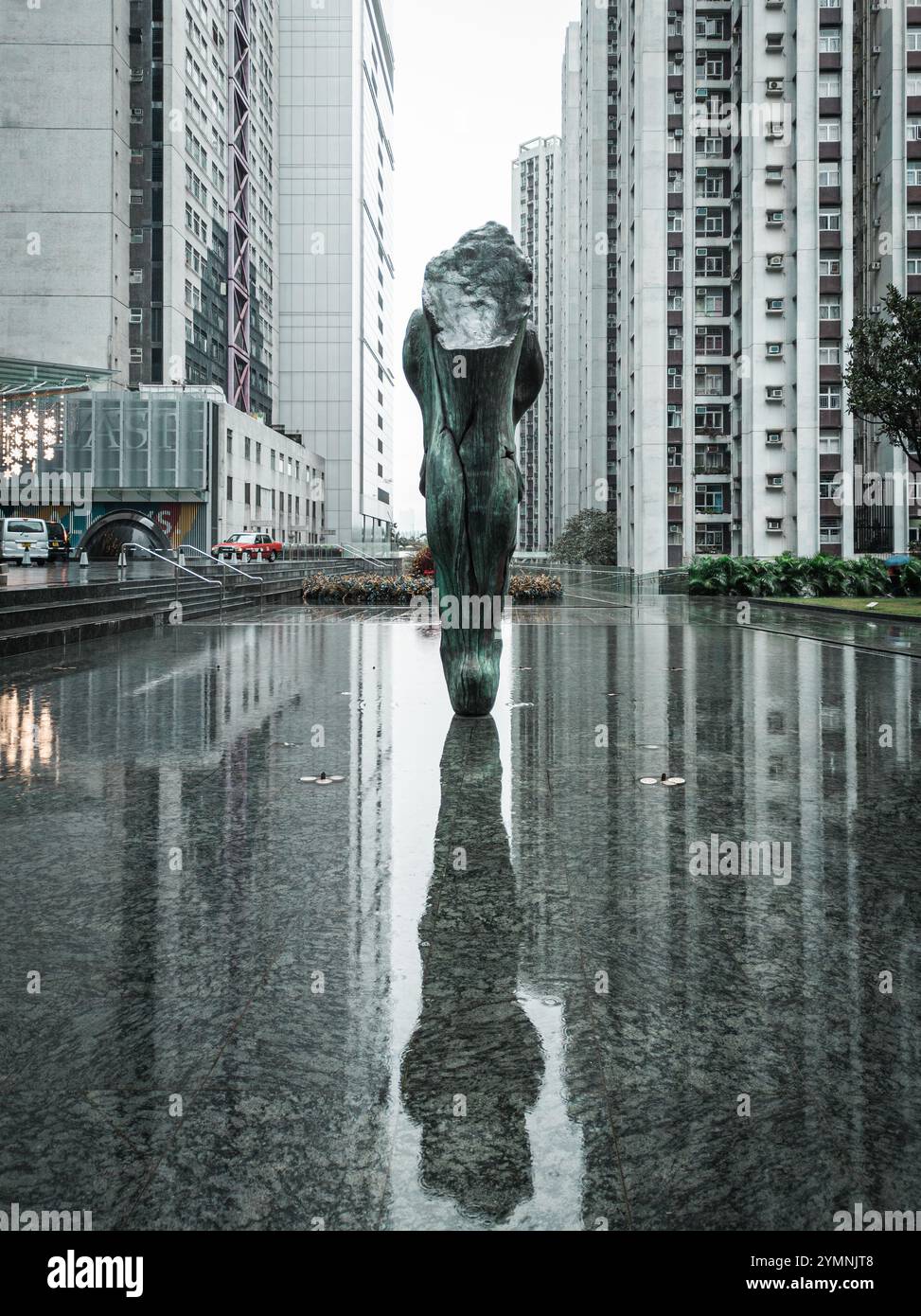 Riflesso astratto della scultura urbana nel moderno e alto paesaggio urbano in un giorno di pioggia Foto Stock