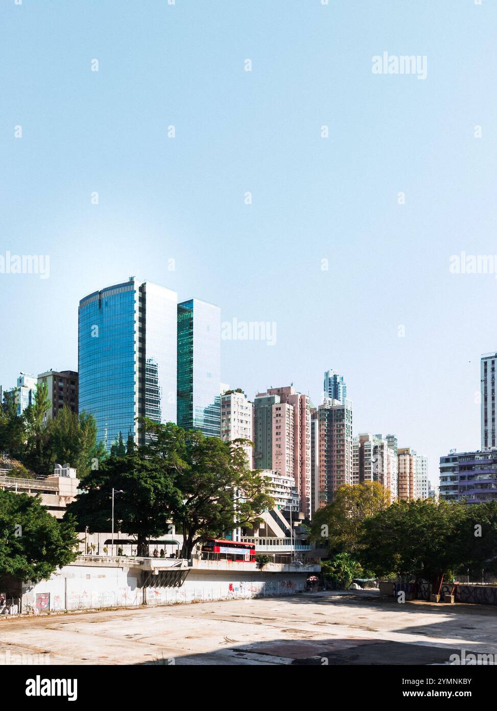 Grattacieli urbani con vegetazione lussureggiante sotto il cielo limpido in un moderno paesaggio urbano Foto Stock