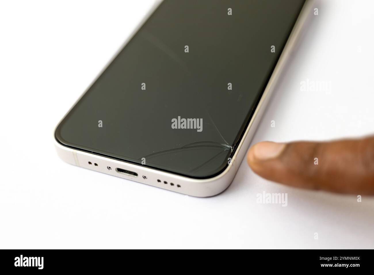 Schermo dello smartphone rotto con il dito rivolto verso il danno. Incidente, riparazione, assicurazione. Foto Stock